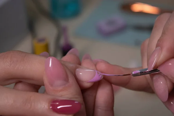 El proceso de hacer manicura. Primer plano de las manos de manicurista profesional, aplicando esmalte de uñas. Concepto de limpieza de manicura y uñas. concepto de belleza. Esmalte de gel, goma laca . — Foto de Stock