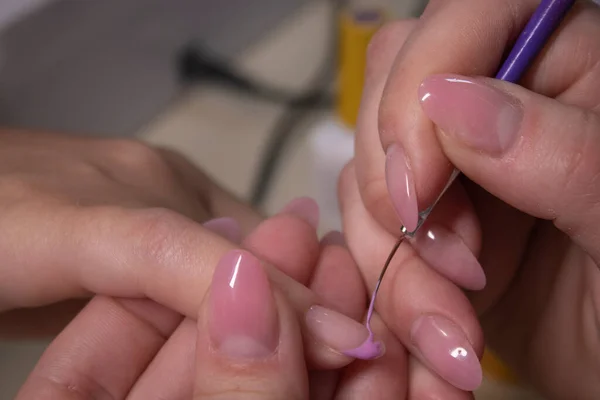 El proceso de hacer manicura. Primer plano de las manos de manicurista profesional, aplicando esmalte de uñas. Concepto de limpieza de manicura y uñas. concepto de belleza. Esmalte de gel, goma laca . — Foto de Stock