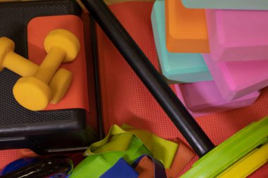 çeşitli parlak spor ekipmanları. Kettlebell, fitness bandı, küp, halı, halter, halter, adım platformu.