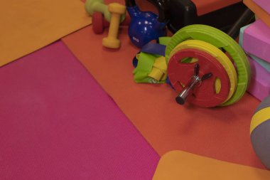 Çeşitli parlak spor ekipmanlarının bileşimini ayarla. Dambıl, bant, top, halı, halter, halter. Spor konsepti.