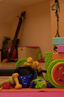 çeşitli parlak spor ekipmanları. Kettlebell, fitness bandı, küp, halı, halter, halter, adım platformu.