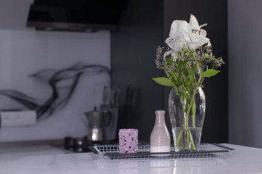 Ev dekorasyonu - mum, vazo ve çiçekler - mutfaktaki el yapımı siyah metal tepside. ev içi konsept