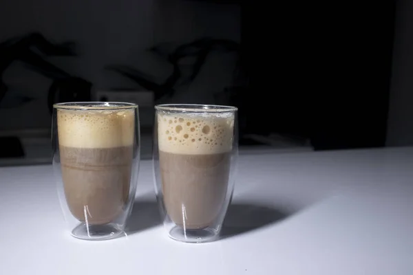 Dva šálky kávy v double-botoom skla na bílém stole v šedé kuchyni — Stock fotografie