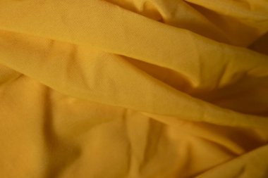 Sarı kumaş, ipek, dokulu arka plan. Tasarım kağıdı, arkaplan metni, afişler, reklam panoları, broşürler için uygun