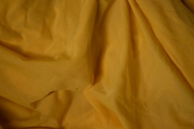 Sarı kumaş, ipek, dokulu arka plan. Tasarım kağıdı, arkaplan metni, afişler, reklam panoları, broşürler için uygun