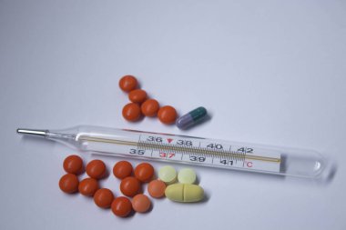 Beyaz arka planda bir sürü haplı cıva termometresi. Tıp ve hastalık konsepti. İzole edilmiş