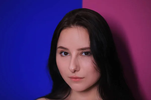 Retrato emocional de uma menina morena em um fundo rosa-azul — Fotografia de Stock