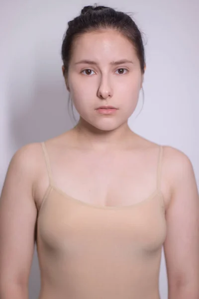 Retrato emocional de morena atraente, atriz em uma camiseta bege - bodysuit em fundo branco. espaço para texto — Fotografia de Stock