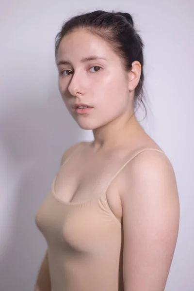 Retrato emocional de morena atraente, atriz em uma camiseta bege - bodysuit em fundo branco. espaço para texto — Fotografia de Stock