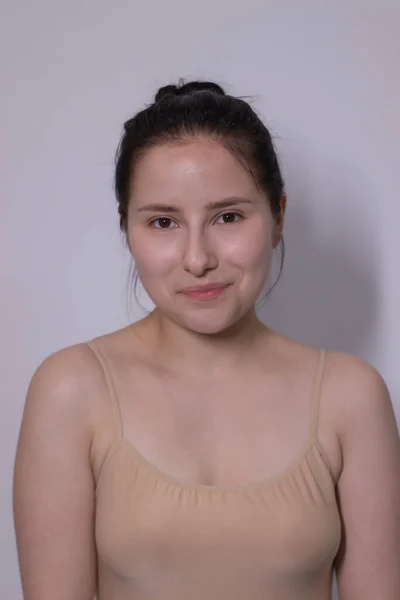 Emotionales Porträt der attraktiven Brünetten, Schauspielerin im beigen Unterhemd - Body auf weißem Hintergrund. Raum für Text — Stockfoto