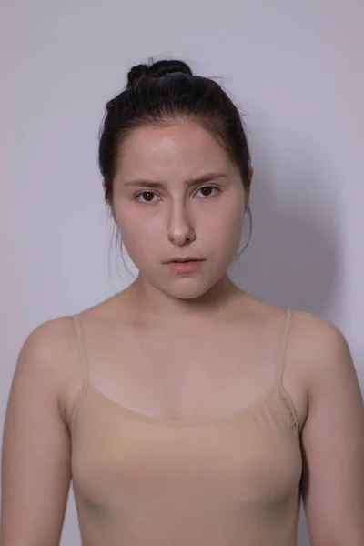 Emotivní portrét atraktivní brunetky, herečky v béžovém tričku - bodysuit na bílém pozadí. mezera pro text — Stock fotografie