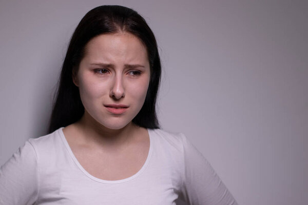  portrait of sad and depressed young woman. on gray background. nervous and upset people concept