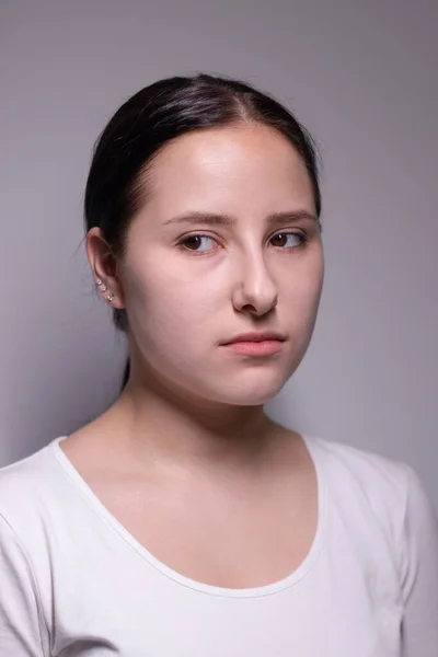 Retrato de una joven triste y deprimida. sobre fondo gris. concepto de personas nerviosas y alteradas —  Fotos de Stock