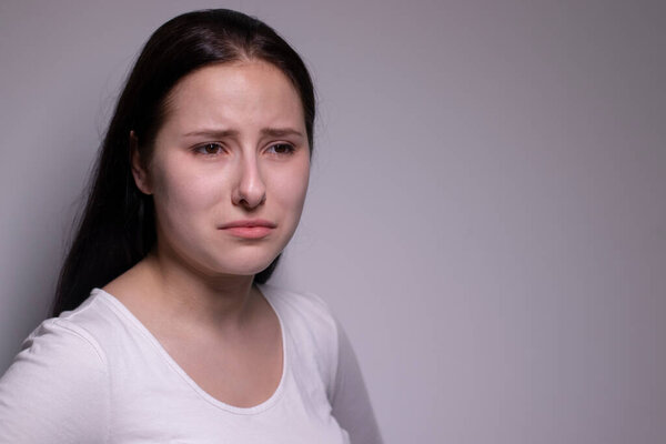  portrait of sad and depressed young woman. on gray background. nervous and upset people concept