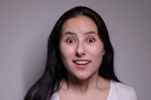 Mujer morena sorprendida, aislada sobre fondo gris. retrato de actriz feliz. emociones humanas, concepto de expresión facial —  Fotos de Stock