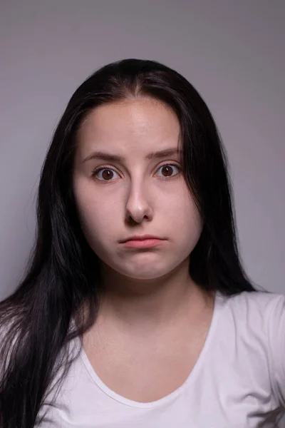 Förtrollad brunett kvinna, isolerad på grå bakgrund. Glad skådespelerska porträtt. mänskliga känslor, ansiktsuttryck koncept — Stockfoto