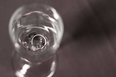 Noel ağacı için mavi parlak süslemenin yanında şampanya bardağında bir nişan yüzüğü. yeni yıl öneri teması