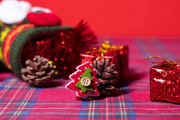 Kerstversiering op rode achtergrond: cadeautjes en dennenappels en sokken met kerstman, knutselen en kerstbomen. 2021 nieuwjaarsthema. template voor ansichtkaarten — Stockfoto