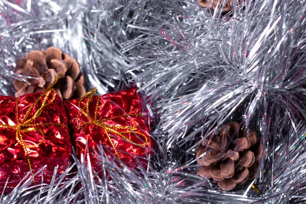 Novoroční dekorace - červené dárky, kornouty a sněhové vločky ve stříbrném cínu na vánoční stromeček — Stock fotografie