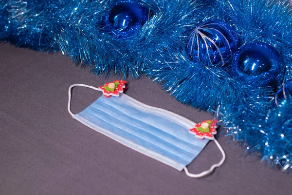 blue medical mask with christmas tree-shaped clothespins. new years medical flatly photo