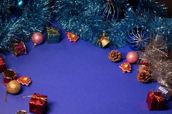 Navidad foto plana sobre fondo azul. diferentes decoraciones de año nuevo: conos, árboles de Navidad, regalos, copos de nieve, juguetes. Espacio de copia — Foto de Stock