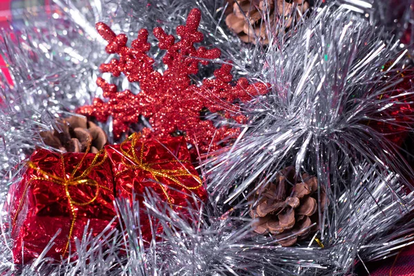 Novoroční dekorace - červené dárky, kornouty a sněhové vločky ve stříbrném cínu na vánoční stromeček — Stock fotografie