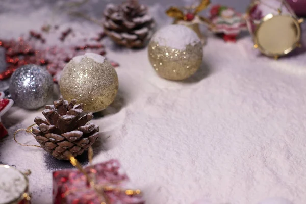 Πρωτοχρονιάτικα στολίδια στο χιόνι. Χριστουγεννιάτικα δέντρα, μπάλες, νιφάδες χιονιού, δώρα, κώνους. Χριστουγεννιάτικη διάθεση. Τυφλή φωτογραφία — Φωτογραφία Αρχείου