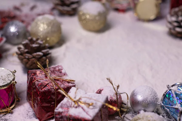 Decoraciones de Año Nuevo en la nieve. Árboles de Navidad, bolas, copos de nieve, regalos, conos. Humor de Navidad. Foto plana — Foto de Stock