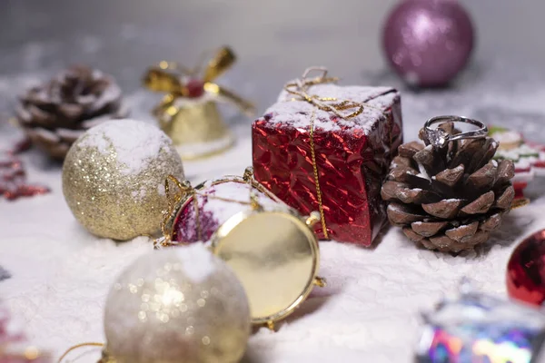 Stříbrný zásnubní prsten šperky vedle novoroční dekorace ve sněhu. Vánoční stromky, koule, sněhové vločky, dárky, kornouty. Vánoční náladu. Flatly photo — Stock fotografie