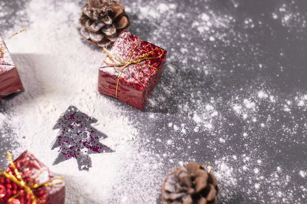 Decorazioni natalizie, regali e pigne nella neve e la silhouette di un albero di Natale. L'umore natalizio. Foto flatly — Foto Stock