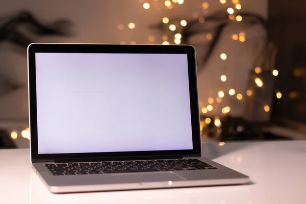 Yeni yıl dekorasyonlarına yakın beyaz ekranlı bir laptop. Noel teması. şablon