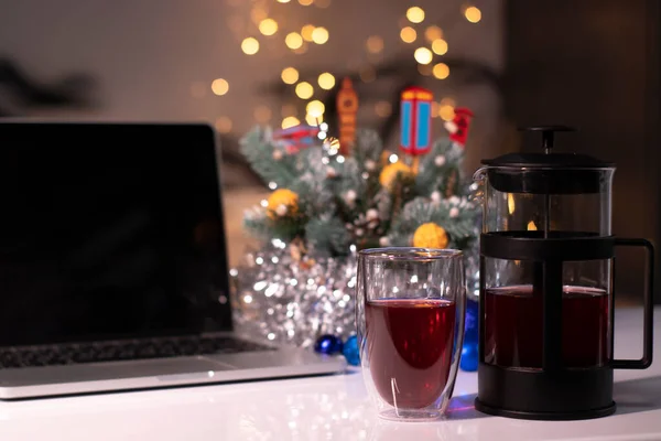 Laptop s černou obrazovkou vedle francouzského tisku a čaje v blízkosti novoroční dekorace. šablona vánočního motivu — Stock fotografie
