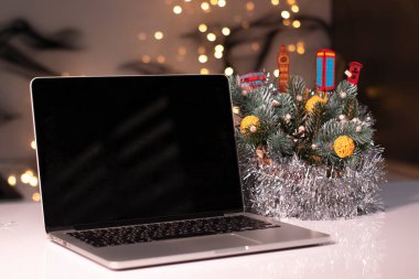 Yılbaşı dekorasyonlarına yakın siyah ekranlı bir laptop. Noel teması. şablon