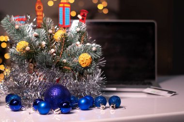 Yeni yıl dekorasyonlarına yakın siyah ekranlı ve kredi kartlı bir laptop. Noel alışveriş teması. şablon
