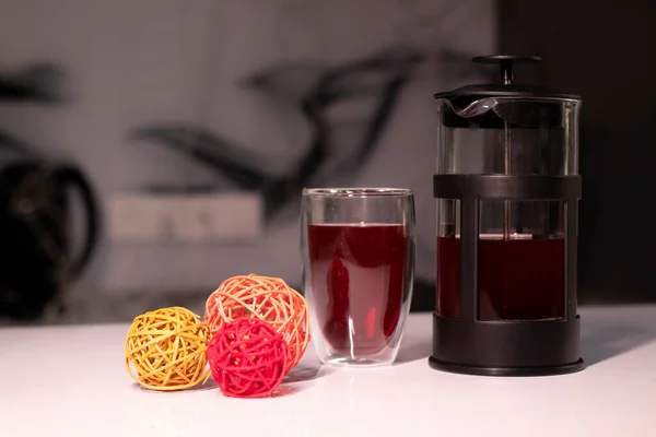 Francouzský lis a čaj ve dvojitém dnu vedle pletených míčků na dekor — Stock fotografie