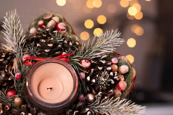 Kerstdecor stervormig gemaakt van boomtak met nieuwjaarsspeelgoed en een kaars erin — Stockfoto