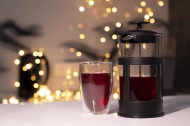 Fransız presi ve çay, arka planda altın sarısı, turuncu bokeh.