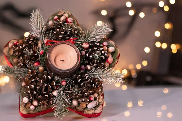 Χριστουγεννιάτικη διακόσμηση σε σχήμα αστεριού από κλαδί δέντρου με παιχνίδια της νέας χρονιάς και ένα κερί σε αυτό — Φωτογραφία Αρχείου