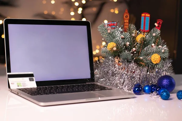Laptop com tela branca e cartão de crédito perto de decorações de Ano Novo. Tema de compras de Natal. Modelo — Fotografia de Stock