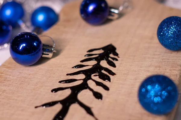 在新年装饰品旁边的木板上用巧克力做成的圣诞树 — 图库照片