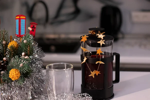 French press and tea in double-bottom glass near New Years decorations. Christmas theme — Stock Photo, Image