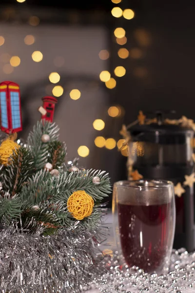 French press and tea in double-bottom glass near New Years decorations. Christmas theme — Stock Photo, Image