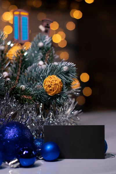 Kerstdecor: boomtak met, nieuwjaarsspeelgoed, rieten ballen, knutselen. zwart visitekaartje. Kopieerruimte — Stockfoto