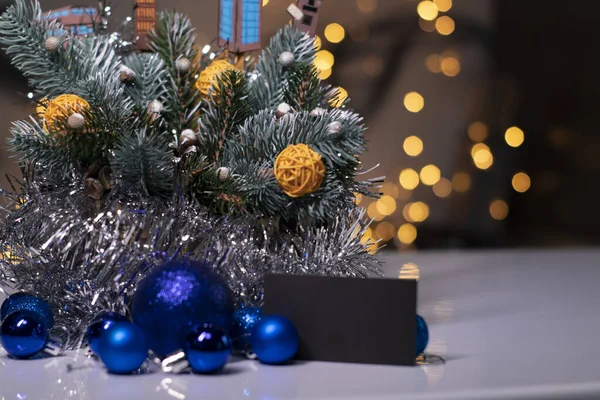 Decorazione natalizia: ramo d'albero con, giocattoli di anno nuovo, palle di vimini, fili di lame. biglietto da visita nero. Copia spazio — Foto Stock