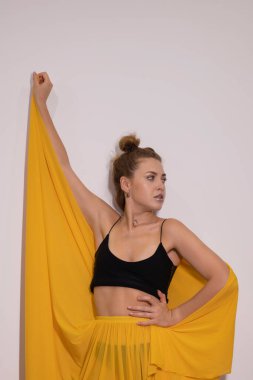 Siyah bluzlu ve sarı etekli seksi sarışın. Gürültü tahıllı moda fotoğrafı.