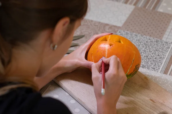 Processen för att göra en Halloween pumpa. Teckna en layout av en brunett flicka. skräcktema och halloween — Stockfoto