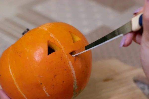 El proceso de hacer una calabaza de Halloween. cortando la nariz. tema de terror y Halloween —  Fotos de Stock