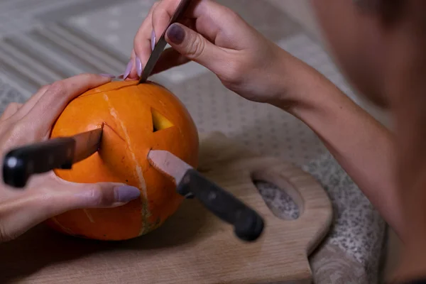 El proceso de hacer una calabaza de Halloween. cuchillos atascados en una calabaza. tema de terror y Halloween —  Fotos de Stock