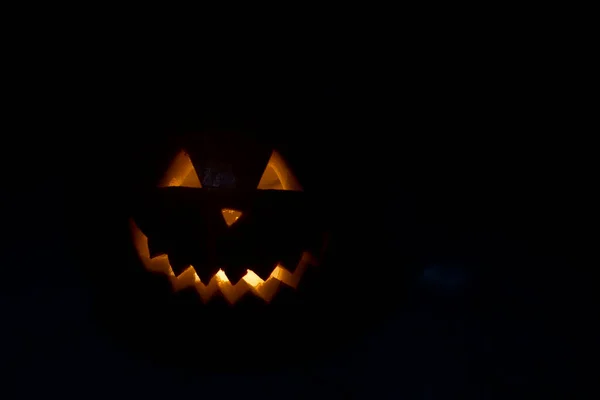 Halloween dýně ve tmě se zapálenou svíčkou uvnitř. hororové téma a Halloween — Stock fotografie