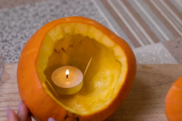 the process of making a Halloween pumpkin. lighted candle. horror theme and Halloween